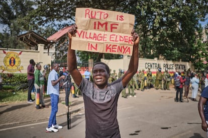 Mutunge Wa Nwangi (27 años) protesta el 9 de junio frente a la comisaría central de policía de Nairobi, con un cartel en el que dice que el presidente del Gobierno de Kenia, William Ruto, “es el Fondo Monetario Internacional”.