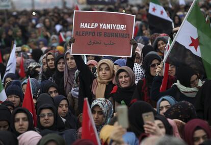 Defensores de un grupo pro-islámico organizan una protesta contra la guerra en Alepo, en el cruce fronterizo de Bab al-Hawa con Siria, cerca de la ciudad de Hatay (Turquía) el sábado 17 de diciembre de 2016. En el cartel se lee en turco y árabe la consigna: 'Alepo se está quemando'.