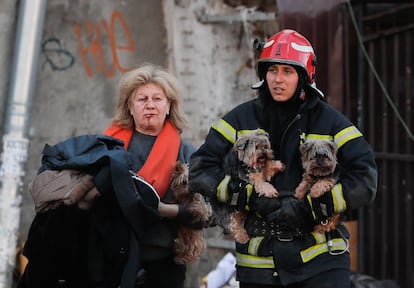 Una bombero ayuda a evacuar a una mujer y sus perros tras el bombardeo ruso contra el centro de Kiev. 