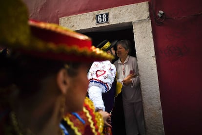 Un hombre con el traje tradicional besa a una mujer en el barrio de Alfama antes de salir a participar en el desfile. En Lisboa se monta una gran verbena, con farolillos y guirnaldas de papel que cruzan las calles de la ciudad antigua.