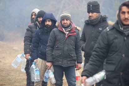 Migrantes con botellas de agua este viernes en la zona de Grodno, en Bielorrusia, junto a la frontera con Polonia.