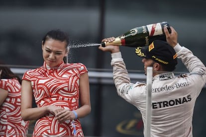Lewis Hamilton comemora sua vitória em Xangai jogando champanhe em uma assistente chinesa.