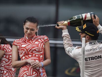 Lewis Hamilton celebra su triunfo en Shanghái rociando de champán a una azafata china.