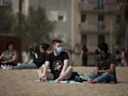 Gent a la platja el passat 31 de març, alguns amb mascareta i d'altres sense. 