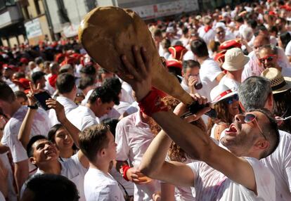 Um homem bebe de uma bota de vinho momentos antes da abertura oficial da festa em Pamplona, neste sábado.