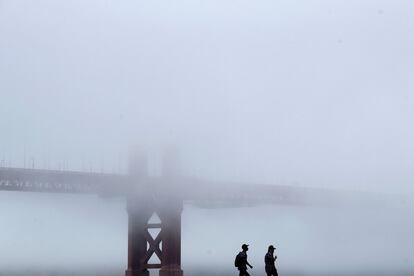 Un pareja camina frente al puente Golden Gate de San Francisco (EE UU).