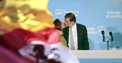 El candidato del Partido Popular a la presidencia del Gobierno, Mariano Rajoy (d), besando a su esposa, Elvira Fernández, durante la celebración de la victoria del PP en las elecciones del 20-N, ante miles de militantes y simpatizantes congregados ante la sede popular de la calle Génova de Madrid, el 20 noviembre de 2011.