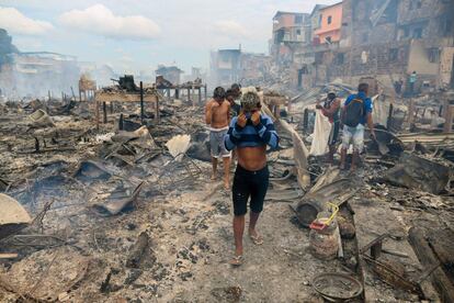 Residentes del barrio Educandos tras la extinción del incendio que azotó la zona, en Manaos (Brasil).