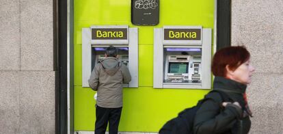 Un usuario utiliza un cajero de una oficina de Bankia.