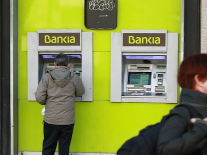 Un usuario utiliza un cajero de una oficina de Bankia.