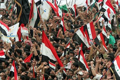 Centenares de iraquíes enarbolan banderas de su país durante una manifestación, ayer en Bagdad.
