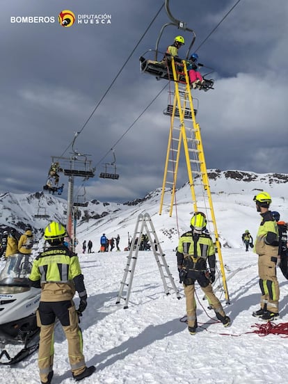 Bomberos rescatan a un esquiador de una de las sillas.