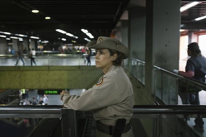 Carolina González, cabo de la milicia, observa a los usuarios del metro en la estación Altamira, en Caracas.