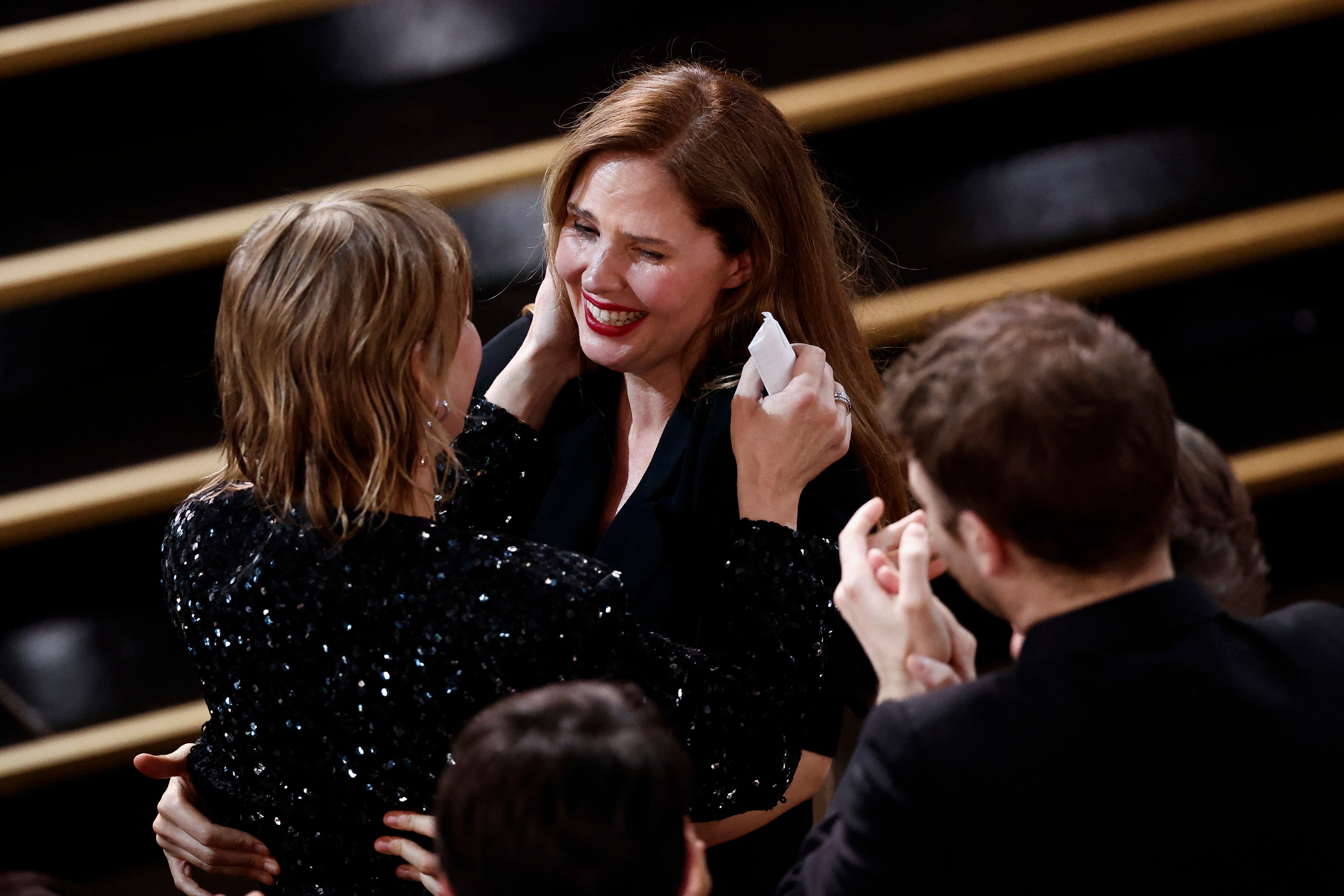 La actriz Sandra Hüller (de espaldas, a la izquierda) recibe la felicitación de Justine Triet tras ganar el premio a la mejor protagonista.