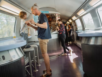 Clement Cost plays with his son in the cafeteria of the high-speed train that links Barcelona to Paris.