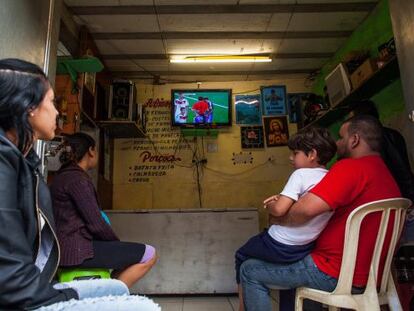 Um grupo de pessoas olha a final em uma favela de São Paulo.