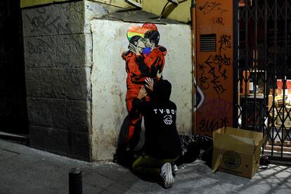 El artista TVBoy pinta el beso entre Tokio y Nairobi de 'La Casa de Papel' en el barrio de Chueca de Madrid.