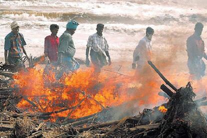 Unos voluntarios incineran cadáveres devueltos por el mar en la playa de Nagapattinam (India).