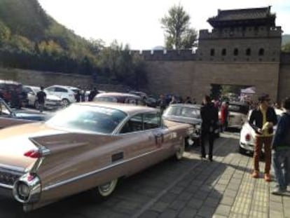 Varias personas observan un Cadillac 62 Coupe De Ville, al pie de la Muralla China, donde coleccionistas de vehículos de época y vendedores de este tipo de autos iniciaron este fin de semana en un viaje de 1.600 kilómetros entre las dos principales ciudades de China, Pekín y Shanghái, con el que quieren fomentar la afición a los grandes clásicos del motor en el país asiático.