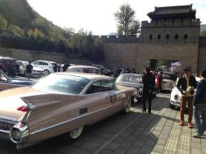 Varias personas observan un Cadillac 62 Coupe De Ville, al pie de la Muralla China, donde coleccionistas de vehículos de época y vendedores de este tipo de autos iniciaron este fin de semana en un viaje de 1.600 kilómetros entre las dos principales ciudades de China, Pekín y Shanghái, con el que quieren fomentar la afición a los grandes clásicos del motor en el país asiático.