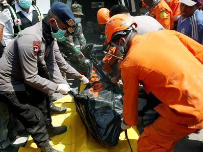 Miembros de los servicios de rescate retiran el cuerpo de una de las víctimas del terremoto en Indonesia.