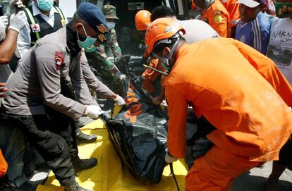 Miembros de los servicios de rescate retiran el cuerpo de una de las víctimas del terremoto en Indonesia.