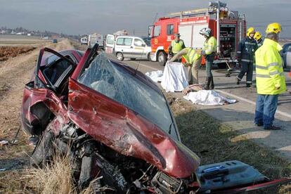 Un agente cubre el cadáver de uno de los tres maetros fallecidos en un accidente en Guadalajara.