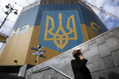 Un hombre habla por teléfono junto a un edificio decorado con los colores nacionales junto a la plaza Maidán en Kiev, este martes.