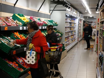 Varias personas hacen la compra en un supermercado en Madrid.