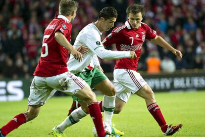 Cristiano Ronaldo lucha por el balón con Michael Silberbauer y William Kvist Jorgensen.