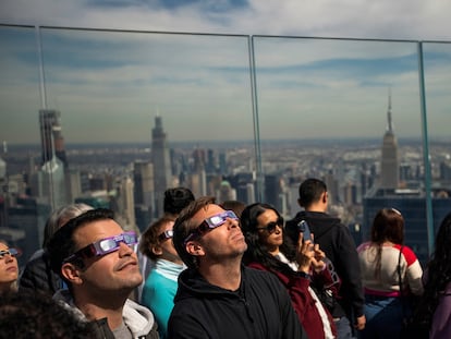 La gente observa el eclipse solar parcial desde el Observatorio The Edge, en Nueva York.