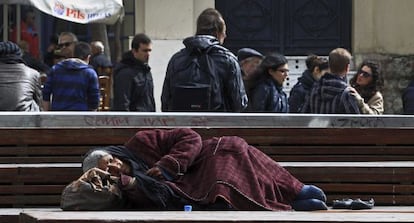 Una anciana indigente duerme en un banco en Atenas (Grecia).