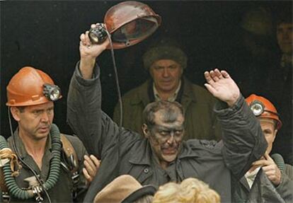 Uno de los cuatro trabajadores rescatados hasta el momento de la mina de Novoshakhtinsk saluda al ver la luz tras 40 horas de encierro.