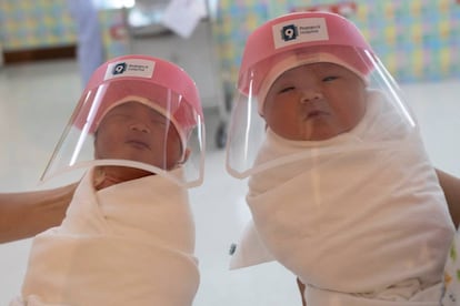 Bebés con sus protectores faciales en un hospital de Bangkok.