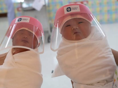Bebés con sus protectores faciales en un hospital de Bangkok.