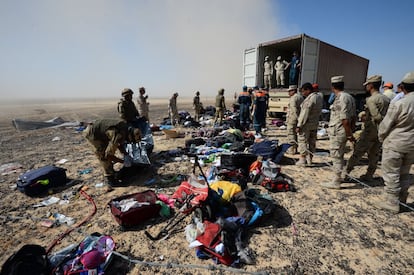 Soldados egipcios recogen pertenencias de los viajeros del avión accidentado en Hassan, península del Sinaí (Egipto).