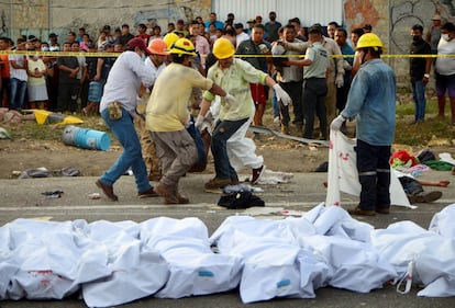 Hombres cargan un cuerpo en el lugar del accidente, cerca de Tuxtla Gutiérrez, en Chiapas.