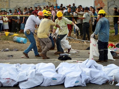 Hombres cargan un cuerpo en el lugar del accidente, cerca de Tuxtla Gutiérrez, en Chiapas.