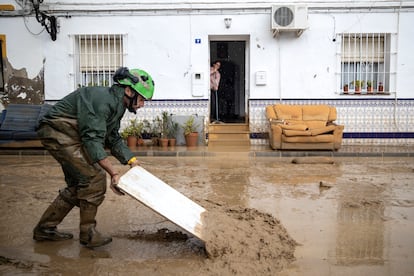 Varios efectivos del Infoca limpian las calles de barro de la barriada de Doña Ana de la localidad de Cartama (Málaga), tras la crecida del río Guadalhorce por el paso de la dana, el 30 de octubre.