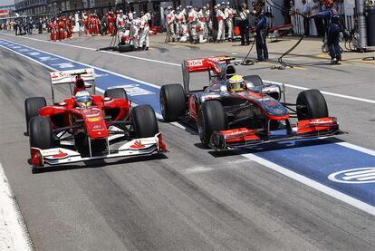 Fernando Alonso y Lewis Hamilton regresan a la pista después de cambiar neumáticos y se encuentran en mitad del <i>pit-lane</i>.- Alonso se colocaría por delante del británico y lideraría la carrera