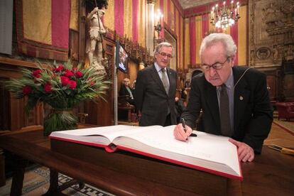 John Banville firma en el libro de dedicatorias de Sant Jordi en el Saló de Cent con la presencia de Xavier Trias.