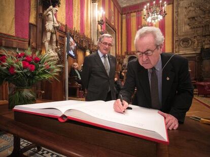 John Banville firma en el libro de dedicatorias de Sant Jordi en el Saló de Cent con la presencia de Xavier Trias.