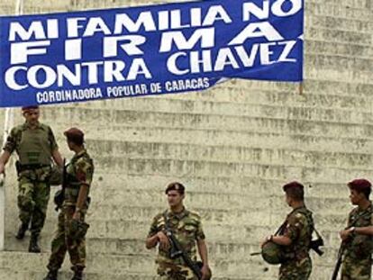 Miembros de la Guardia Nacional venezolana bajo un cartel de apoyo a Chávez, ayer en Caracas.