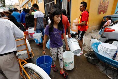 Una niña carga agua para su casa en Ciudad de México.