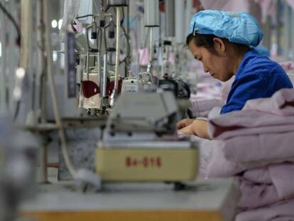 Una trabajadora cose en una empresa de Binzhou, en la provincia de Shandong (China), ropa que será exportada a Estados Unidos. 