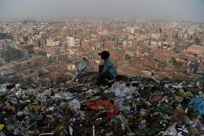 Un niño indio mira la ciudad de Nueva Delhi desde un basurero en el vertedero de Bhalswa.