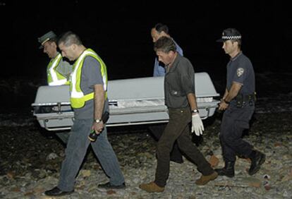 Agentes de la Guardia Civil trasladan el cuerpo del subsahariano hallado muerto en Ceuta.