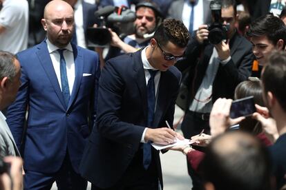 El jugador del Real Madrid, Cristiano Ronaldo, firma autógrafos a su llegada al Ayuntamiento de Madrid junto al resto de sus compañeros.