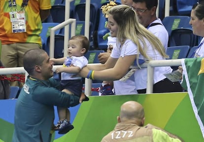 A mulher de Daniel, Raquel, entrega o filho menos para o nadador após a prova.