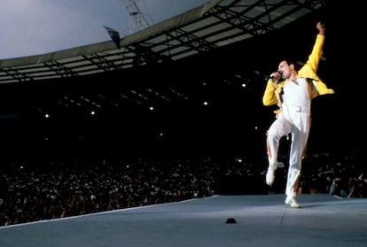 Freddie Mercury levanta su brazo, uno de sus gestos más icónicos, durante una actuación en el escenario del estadio de Wembley que formó parte de su gira 'Magic Tour'.